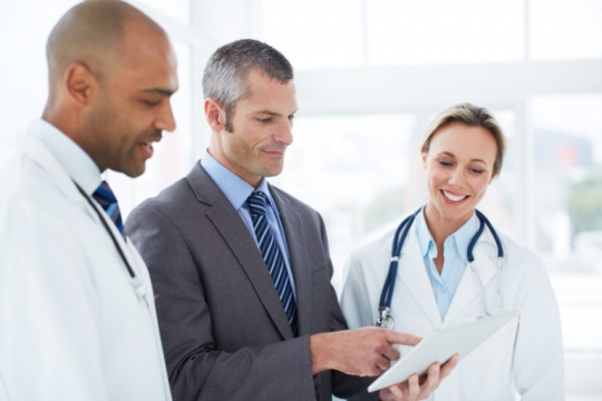 a health care administrator talks to two doctors